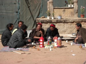 Pilger beim Buttertee vor dem Tempel - der Tee wird praktischerweise immer in Thermosflaschen mitgebracht