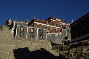 ...manche Gebaude des grossen Sakyaklosters sind auf die Haenge dahinter gebaut - die  Mauerfarben Grau-Rot-Weiss sind chartakteristisch fuer Sakya